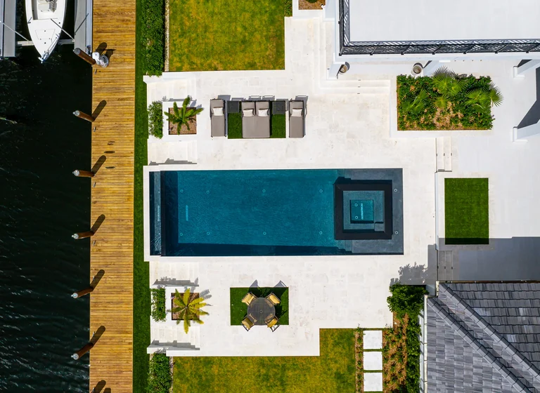 Aerial view of a waterfront residence with a pool and private dock