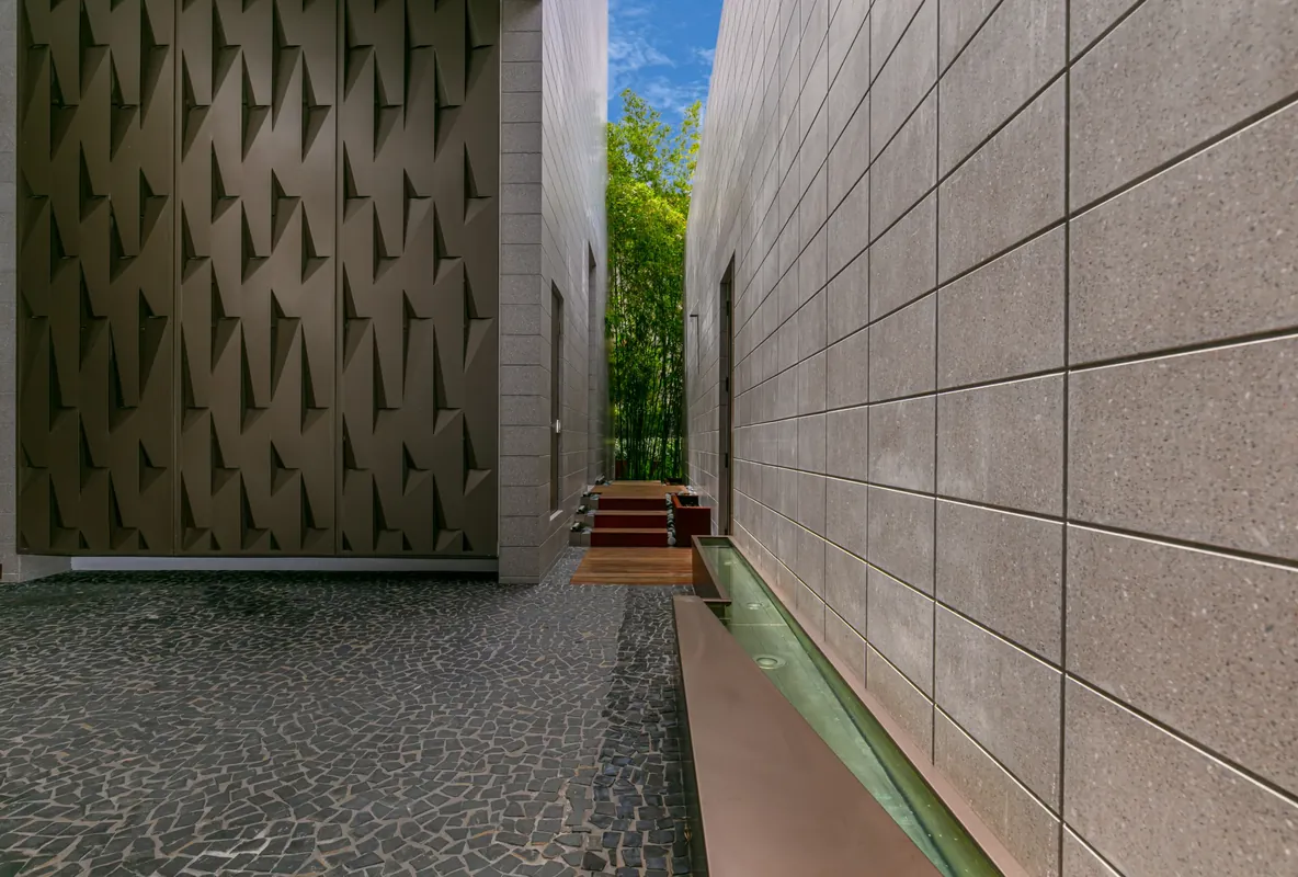 Textured stone wall running alongside a narrow water channel